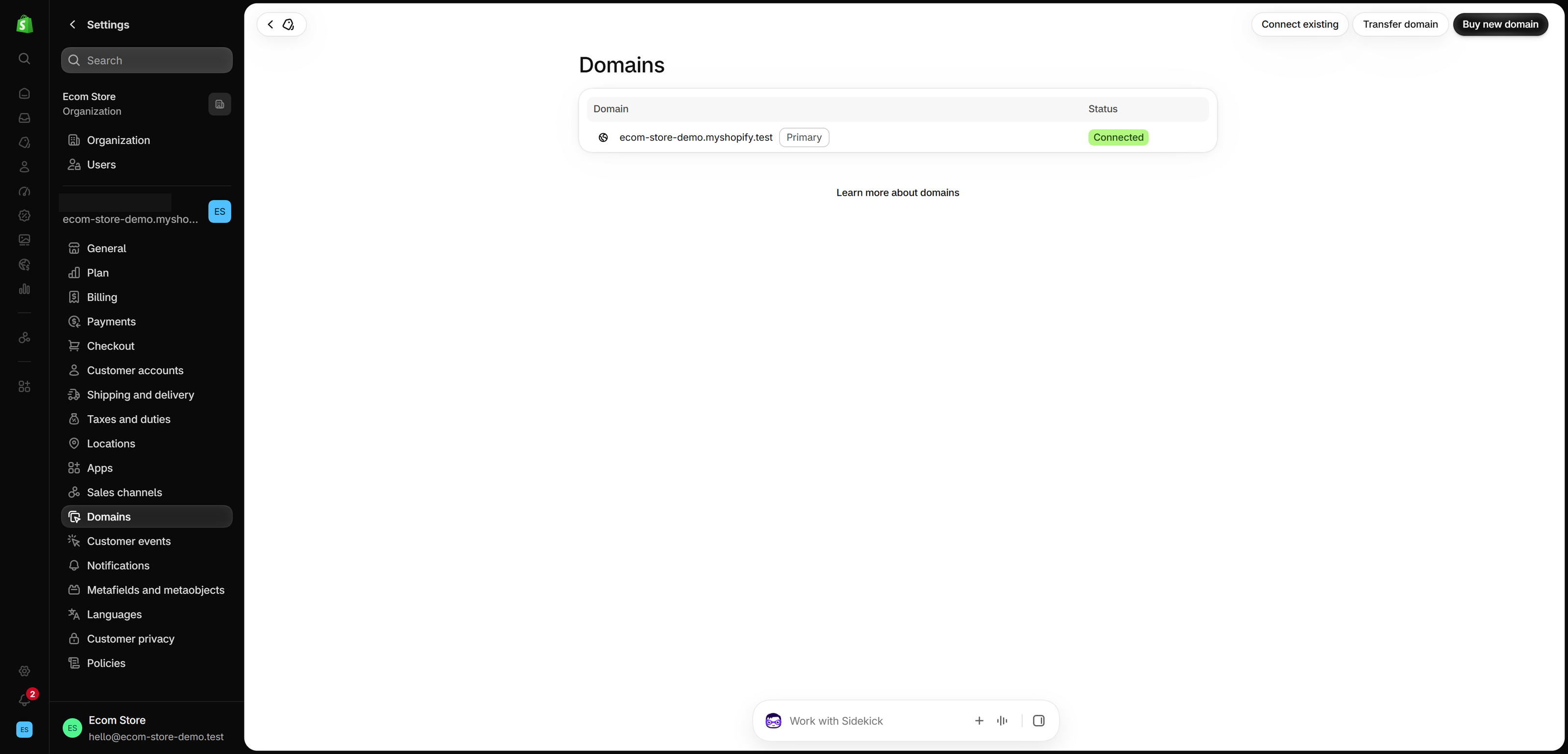 Settings > Domains in the Shopify admin listing one myshopify address marked Primary and Connected, with Connect existing, Transfer domain and Buy new domain buttons